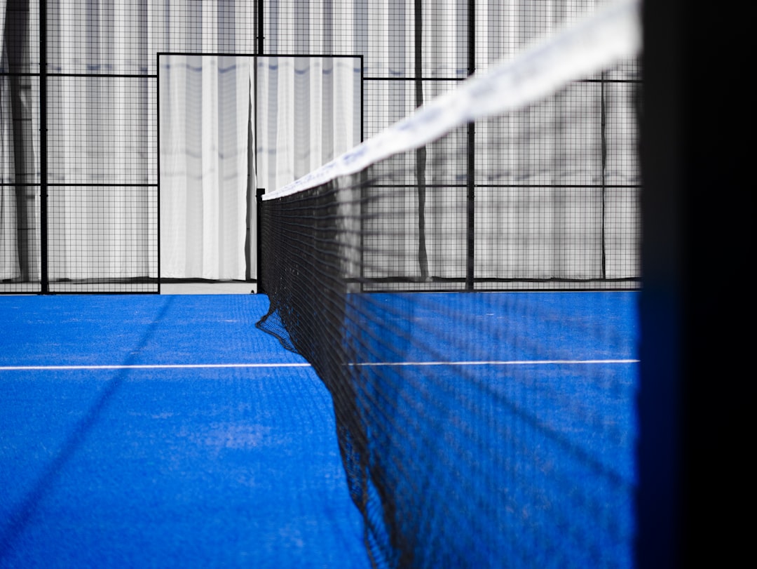 Lapangan padel dengan dinding kaca transparan dan jaring net
